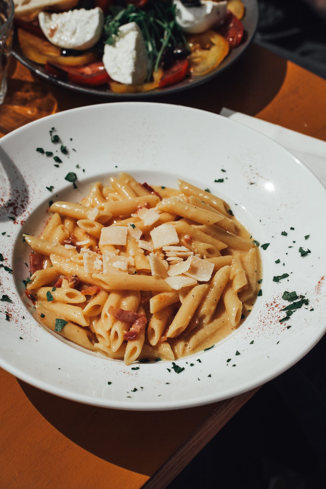 Une assiette de pennes à la sauce tomate et copeaux de parmesan